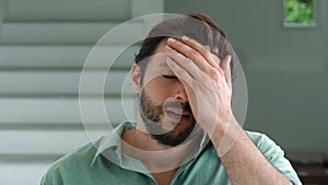 Charming young bearded dark-haired Caucasian man feels shocked by what he saw, he covers his face and expressing denial