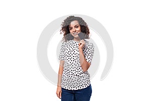 charming young brunette curly woman dressed in pea print summer blouse holding plasty card mockup