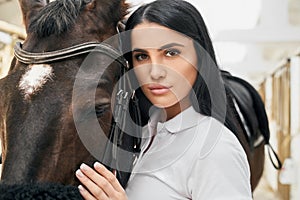 Charming young lady hugging beautiful purebred horse