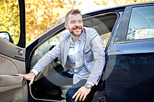 Charming young man getting out of his car