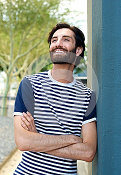 Charming young man smiling with arms crossed