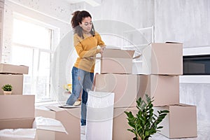 Charming young student packing belongings before moving out