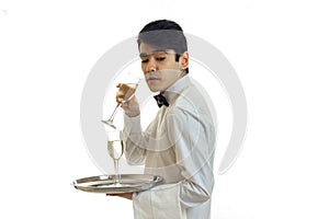 Charming young waiter`s shirt stands sideways quite imperceptibly forward and holds in his hand a glass of wine