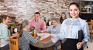 Charming young waitress warmly welcoming guests to family cafe