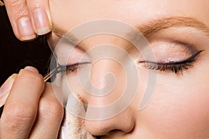 Charming young woman applying blusher eyelid photo