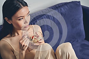 Charming young woman eating oatmeal at home