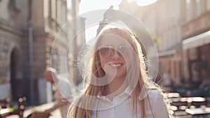 Charming young woman with a magnificent brown hair and stylish sunglasses. Attractive young lady is rushing in the city