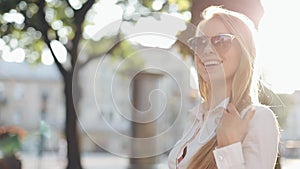 Charming young woman with a magnificent brown hair and stylish sunglasses. Attractive young lady is rushing in the city