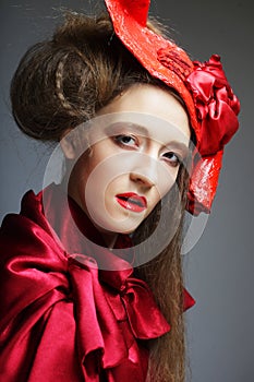 Charming young woman in a red carnival costume and hat.