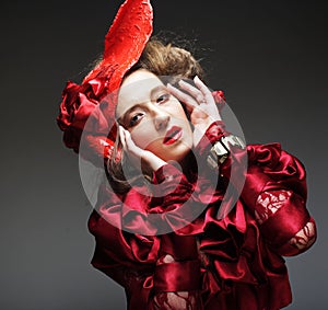 Charming young woman in a red carnival costume and hat.