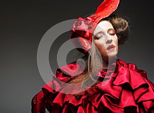 Charming young woman in a red carnival costume and hat.