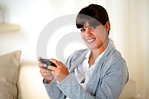 Charming young woman sending message by cellphone