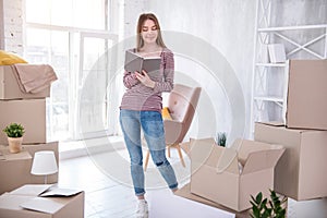 Charming young woman studying list of belongings