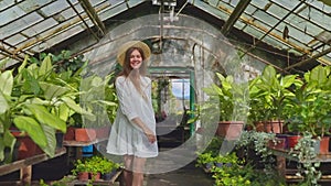 charming young woman in sunny greenhouse of organic farm in summer vacation, portrait in movements