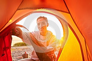 Charming young woman unzipping camp tent in the morning