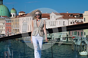 Charming young woman walking in Venice, Italy. Italian summer vacation. Fashion woman on the Venice street. Traveler