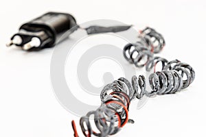 Charred charger wire, close-up. White background. Closeup. Short-circuited and fire concept