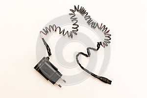 Charred charger wire, close-up. White background. Flat lay. Short-circuited and fire concept