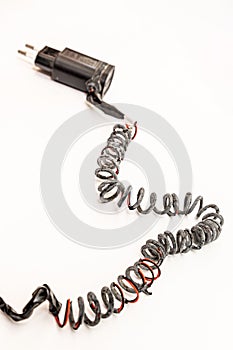 Charred charger wire, close-up. White background. Vertical orientation. Closeup. Short-circuited and fire concept