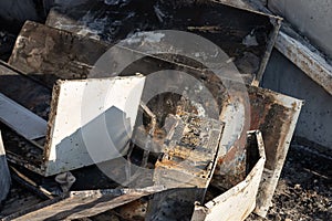 Charred PC system unit among the ruins after a fire.