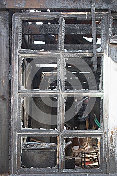 Charred window of a burnt house