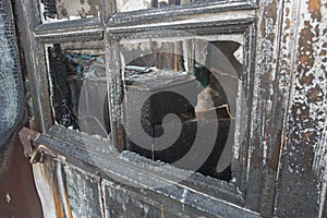 Charred window of a burnt house