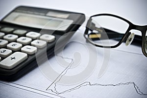 Chart, calculator, glasses as financial stock analysis concept