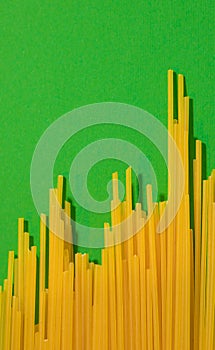 A chart of success made from raw spaghetti on a vibrant green background with copy space. Flat lay minimal arrangement.