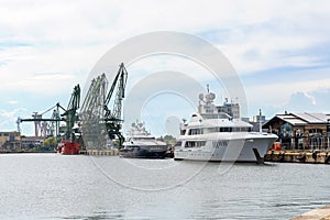 The charter yacht Mustique in the port of Varna, Bulgaria. Two luxury yachts moored at the pier on a spring day. Expensive super