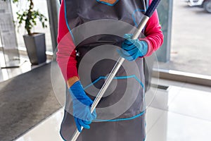 charwoman in apron and gloves, cleaning photo
