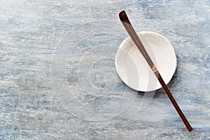 Chashaku Matcha spoon and empty ceramics plate on rustic wooden background.