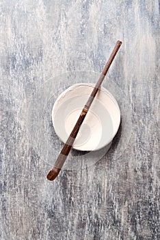 Chashaku Matcha spoon and empty ceramics plate on rustic wooden background.