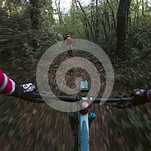 Chasing a rider in a mountain bike race in a single track forest trail