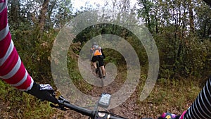 Chasing a rider in a mountain bike race in a single track forest trail