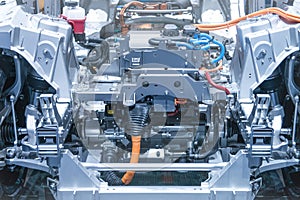 Chassis of the electric car with powertrain and power connections closeup. Blue toned.