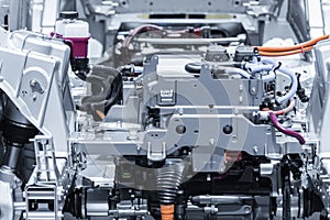 Chassis of the electric car with powertrain and power connections closeup. Blue toned.