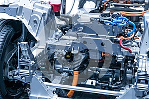 Chassis of the electric car with powertrain and power connections closeup. Blue toned.