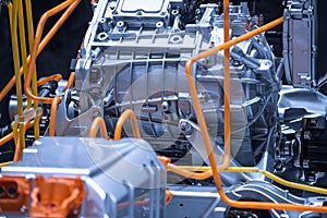 Chassis of the electric car with powertrain and power connections closeup. Blue toned. EV car drivetrain at maintenance.