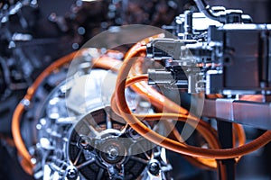 Chassis of the electric car with powertrain and power connections closeup. Blue toned. EV car drivetrain at maintenance.