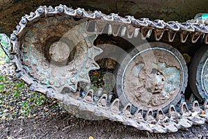 Chassis of tracked military equipment. Metal tracks of a tracked vehicle in dried mud