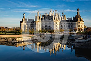 Chateau de Chambord, France reflecting in the water on a sunny day