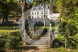 Chateau Gaillard Amboise surrounded by forest park with small bridge over a little stream on the foreground. Loire valley, France.