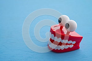 Chattering teeth toy wind up moving on blue background. Funny, comedy, relax time