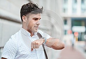 Chatting on a smartwatch with a young creative business man or intern commuting in the city. Hailing a cab, taxi or ride