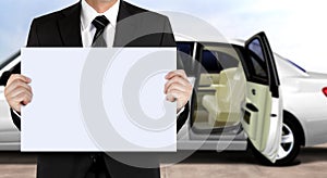 Chauffeur holding signage waiting for passenger with white limo background photo
