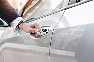 Chauffeur s hand on handle. Close-up of man in formal wear opening a passenger car door