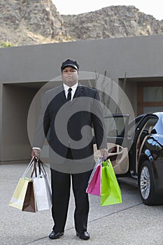 Chauffeur With Shopping Bags In Driveway