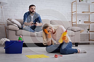 Chauvinism and sexism at home concept. Depressed lady housewife sits on floor photo