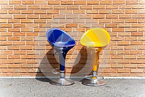 Cheap plastic bar chairs in front of brick walls