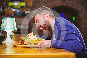 Cheat meal concept. Hipster hungry eat pub fried food. Manager formal suit sit at bar counter. Delicious meal. Man photo